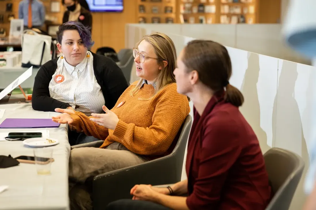 People have a conversation at a table.